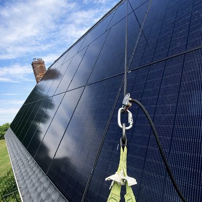 Close-up of black solar panels beside a chimney